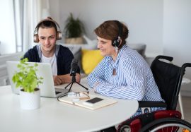 disabled-people-sitting-at-the-table-indoors-at-home-recording-podcast-at-home.jpg
